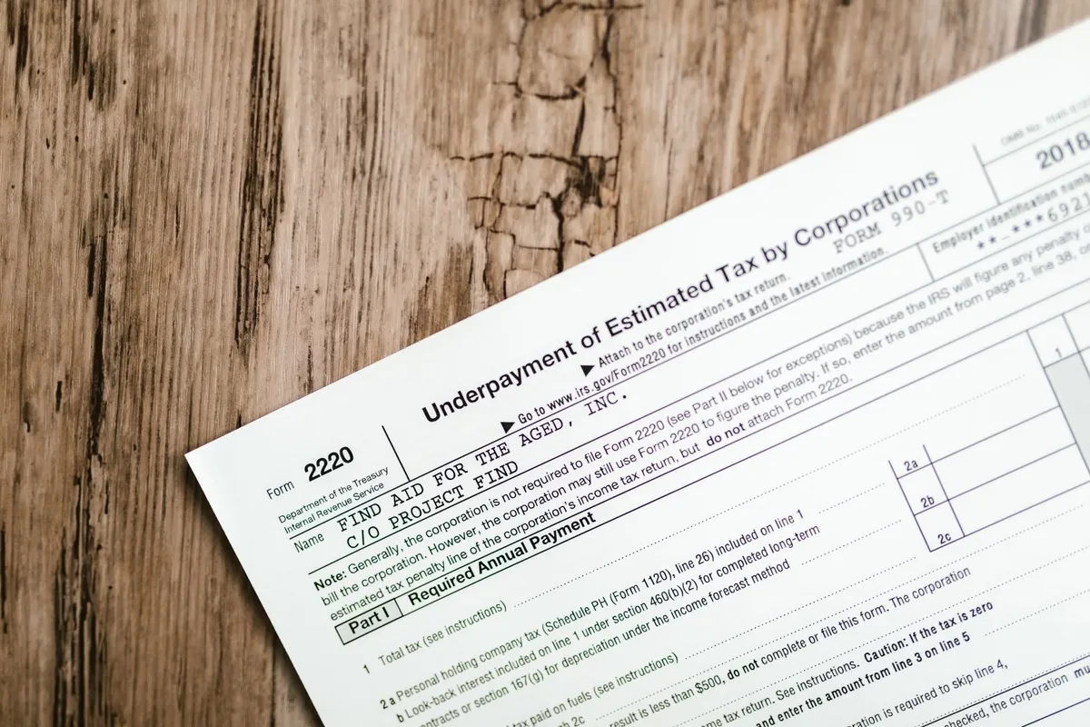 Close-up of a corporate tax form on a wooden surface, emphasizing details relevant to tax resolution.